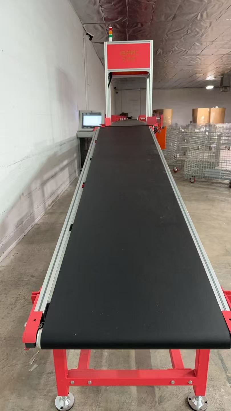 Automated parcel sortation line during installation in Palm Springs, California, looking down the belt toward the scan gantry
